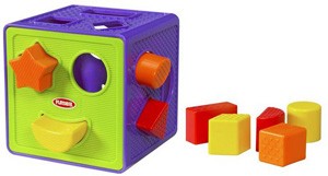Kostka pełna kształtów (firmy Hasbro), dziecko ćwiczy sprawność manualną dopasowując kształt klocka do otworu  
