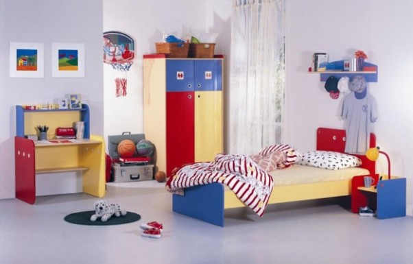 Pokój małego sportowca. Obok biurka i łóżka miły dodatek, kosz na ścianie.  