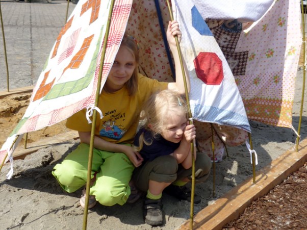 Temat    domu    w zabawach pojawia się u dzieci bardzo wcześnie. Dzieci budują zamki z piasku, namioty i schrony z prześcieradła, koca czy z krzeseł, no i chowają się pod nie, czy pod stół. Wystawa na placu Wolnica w Krakowie. 