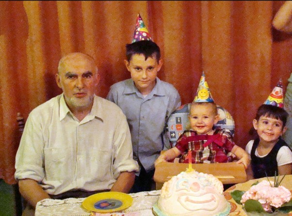 Dziadzio z wnukami Na pierwszych urodzinkach 