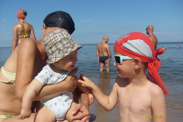 Zdjęcie zgłoszone na konkurs eBobas.pl Moje wakacje \nsą udane.\n Sympatycznego chłopca na plaży poznałem.\n Tak radośnie się z nim bawiłem \nże do wspólnego zdjęcia poprosiłem.