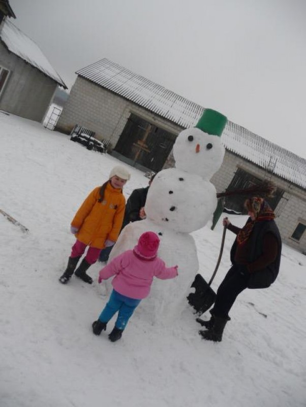 Rodzinne lepienie  Tata i babcia z maluszkami bałwana lepią :P