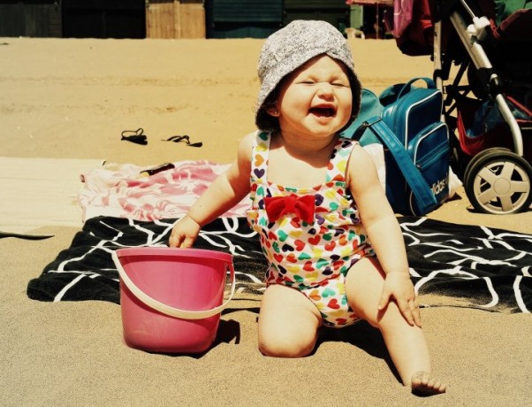 *Roześmiana Plażowiczka* Moja Mała Śmieszka wygrzewająca się na złocistym piasku na plaży w Broadstairs w Wielkiej Brytani. 