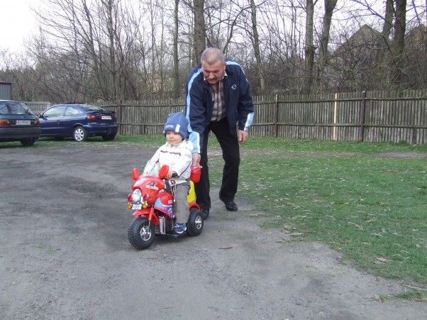 Arturek na motorku Dziadek pomaga wnukowi w pierwszej jeździe nowym pojazdem. 