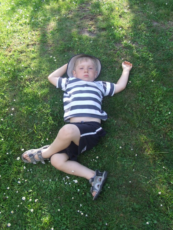 Leżakowanie na trawie Zasłużony odpoczynek w cieniu po dniu pełnym wrażeń. 