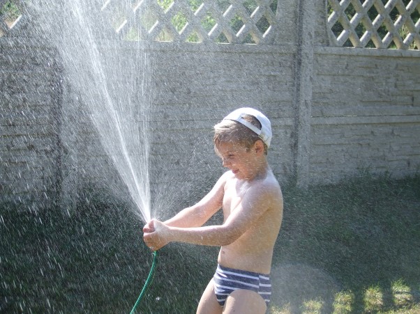 Wakacyjny prysznic w plenerze Jaka jest najlepsza latem ochłoda?\nTo oczywiście z kranu woda!\nArturek dobrze o tym wie,\nwięc chętnie w upał pluska się!