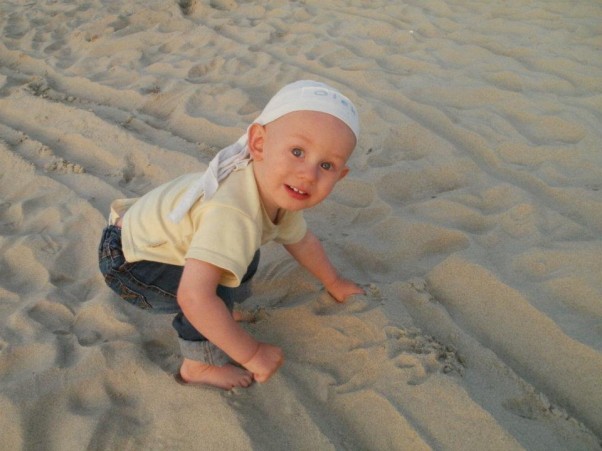 Wakacje w Krynicy Morskiej Synek po raz pierwszy dotyka plażowego piasku, jego zdziwienie jest ogromne