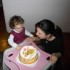 Dwuletniej Asi trzeba pomóc zdmuchnąć urodzinową świeczkę