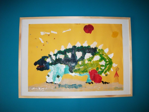 Zdjęcie zgłoszone na konkurs eBobas.pl Ankylozaur na tle wulkanu&#45; zrobiony przez mojego 5letniego syna Damiana&#40;wielkiego miłośnika dinozaurów&#41;, przy użyciu farb, kredek, brokatów i wycinanek na kartce formatu 60x80cm,od razu musiał trafić do ramki i na ścianę:&#41;