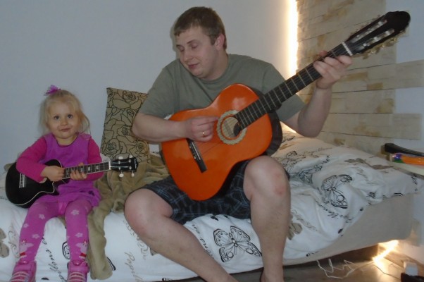 wspólne muzykowanie największa przyjemność to rodzinne granie, córcia na ukulele a tatuś na gitarze