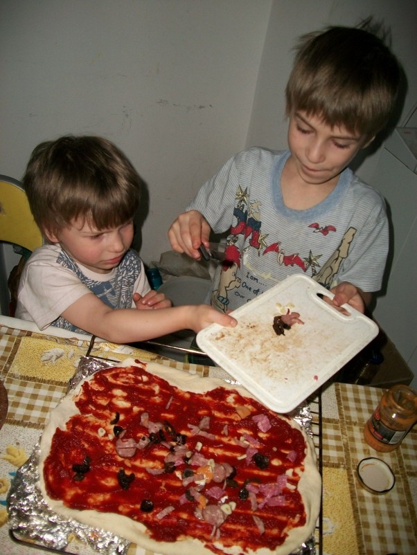 Przepis na domową pizzę Przepis jest prosty: ciasto wg włoskiej receptury, koncentrat pomidorowy, dodatki wg uznania, dużo cierpliwości i kilkoro młodych pomocników wyposażonych w narzędzia kuchenne. Na zdjęciu Jaś i Wojtuś :&#41;