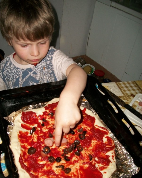 Pizza domowa z ulubionymi dodatkami Wojtuś dodaje kawałki parówki
