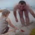 Tata bawi się z córką w piasku,stawia babki z piasku,smieja się i ciesza.