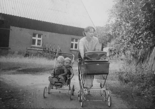 Młoda mama na spacerze z 3&#45;ką dzieci Moja mama w ciągu 3. lat urodziła 3. dzieci. Na tym zdjęciu ma 29 lat i jest w drodze po &#39;wiejskie mleko do gospodarza&#39;. Towarzyszył jej tata, bo wyjść samej z dziećmi w wieku 2,5 i 1,5 lat oraz 6. miesięcy było niemożliwe. Ale chodzili z nami dużo i daleko, dla dzieci wszystko. A że 2,5 letni brat po jakimś czasie kończył w spacerówce młodszego brata nikomu nie przeszkadzało. Ja jestem najmłodsza, była grzeczna i zawsze wszystko przespałam. 