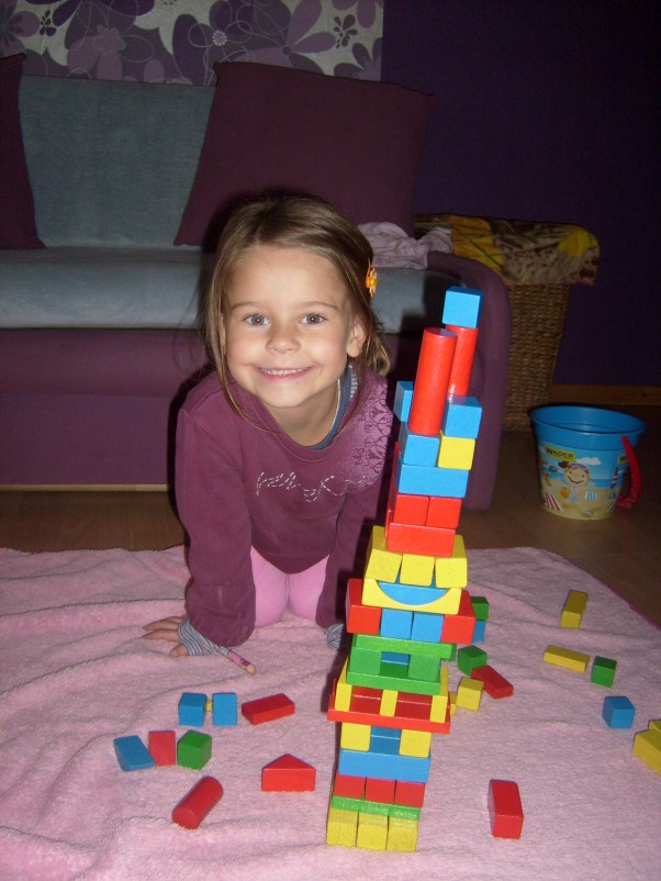 Zdjęcie zgłoszone na konkurs eBobas.pl Martynka bawi się w domu układając wieże z klocków.