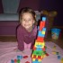 Martynka bawi się w domu układając wieże z klocków.