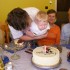 Mikołaj z tatą w wielkim skupieniu zdmuchnują świeczkę z tortu urodzinowego
