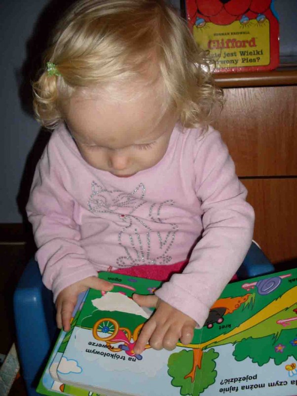 Zaczytana Martusia Marta uwielbia czytać książeczki, pochłaniają ją bez reszty. W końcu ma już niecałe 2 latka.